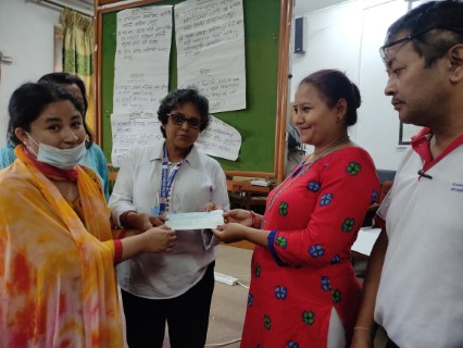 Ms Maheshwori bista rawl handing the cheque to the leader of ward level group of person with disabilities
